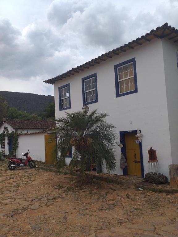 ein weißes Haus mit einer Palme davor in der Unterkunft Loft Largo do Ó in Tiradentes