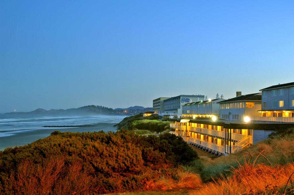 a view of the ocean and buildings at night at Shilo Inn Suites Newport in Newport