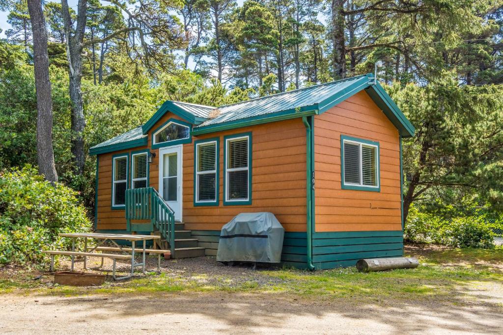 ein winziges Haus im Wald mit einer Veranda in der Unterkunft Whalers Rest in Forfar