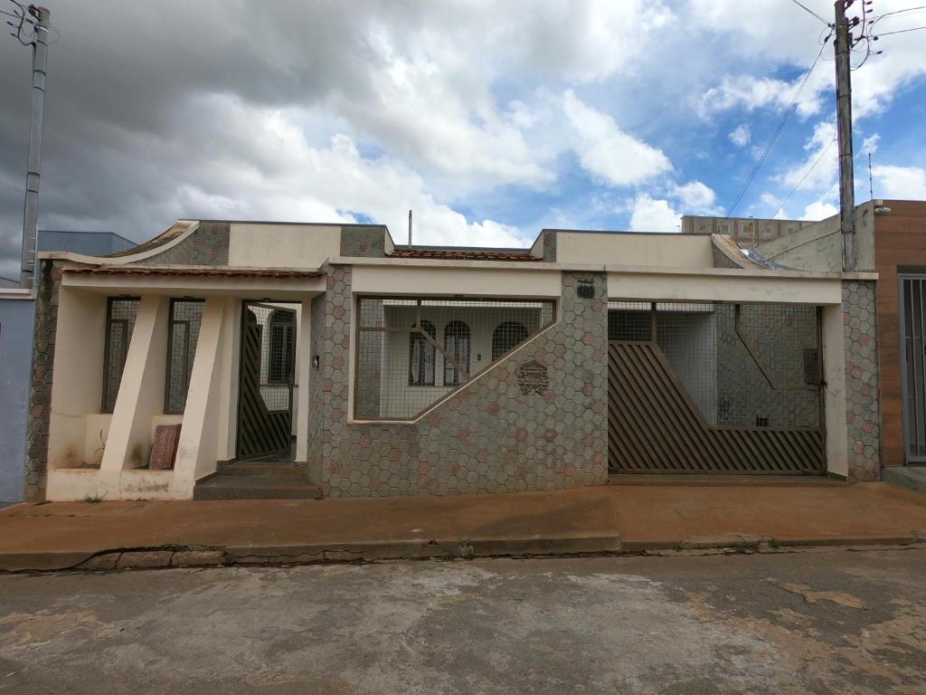 an old brick house with a porch on a street at Casa de Temporada Piumhi in Piumhi