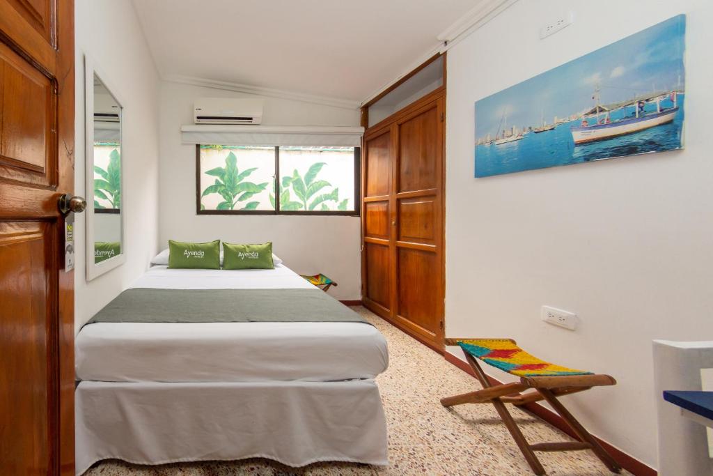 Postel nebo postele na pokoji v ubytování Hotel Ayenda Casa Cano 1805