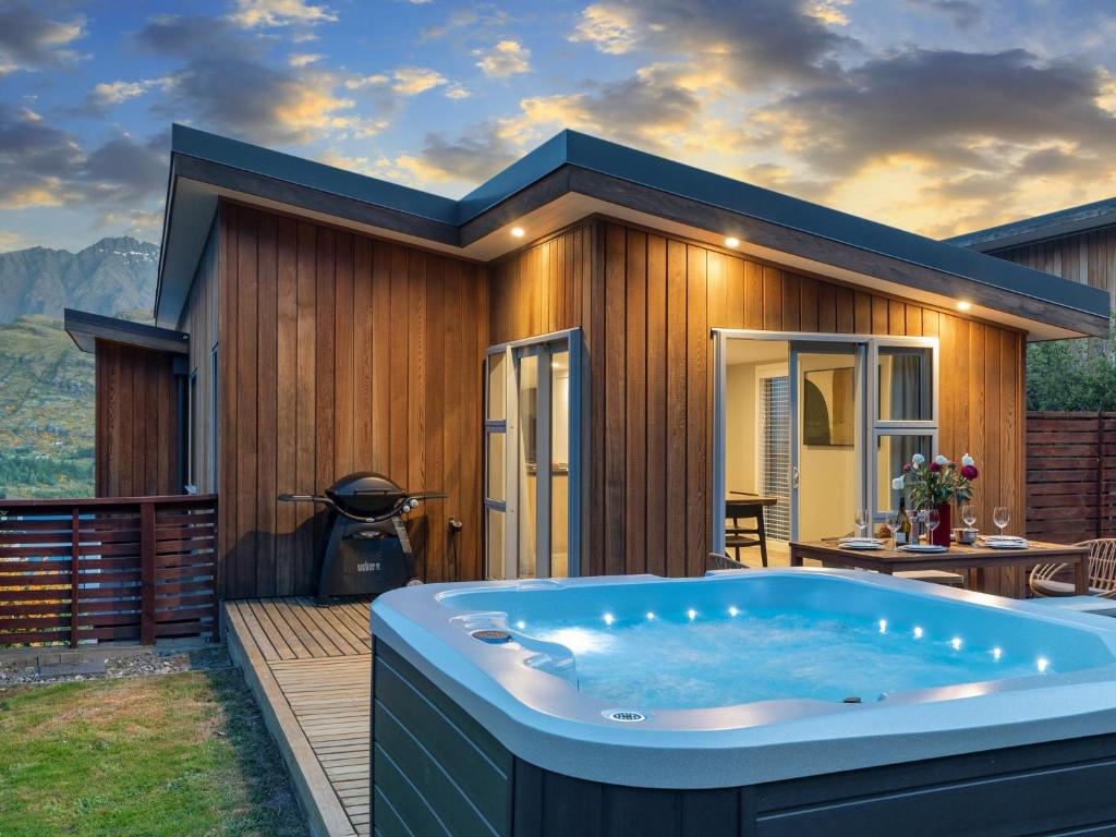 bañera de hidromasaje en la cubierta de una casa en Highview Haven by Relaxaway Holiday Homes, en Queenstown