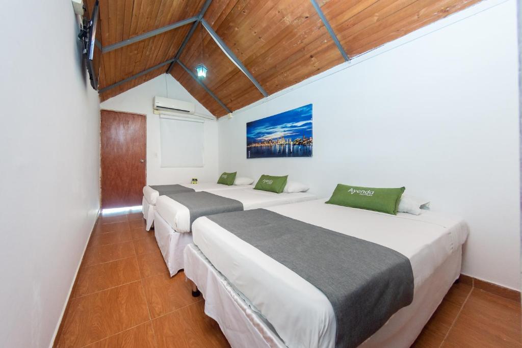 Postel nebo postele na pokoji v ubytování Hotel Ayenda Casa Cano 1805