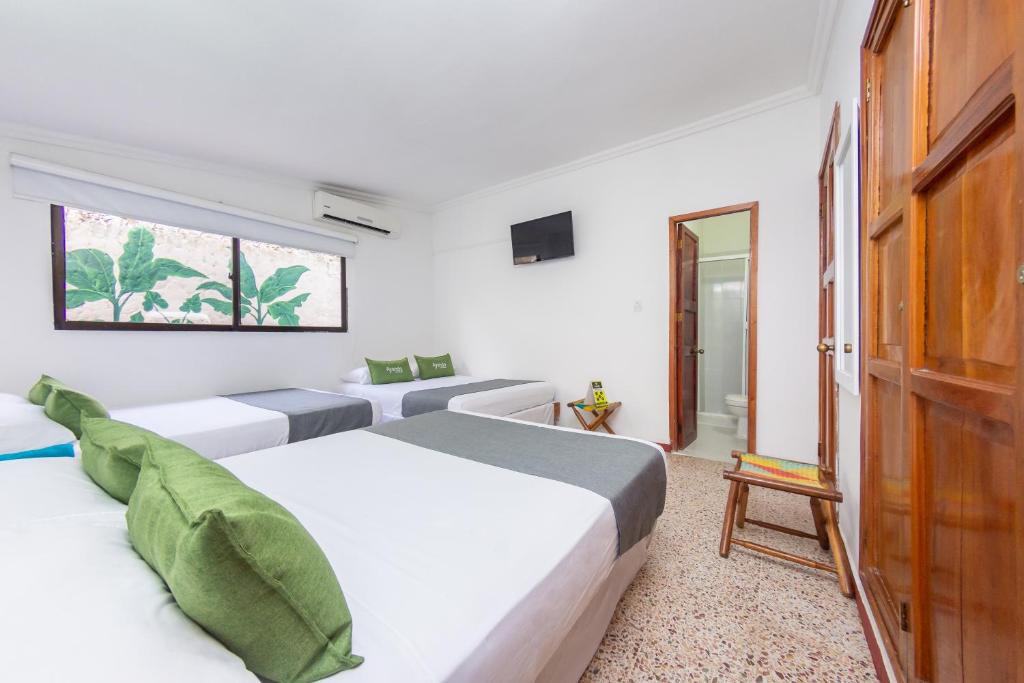 Postel nebo postele na pokoji v ubytování Hotel Ayenda Casa Cano 1805