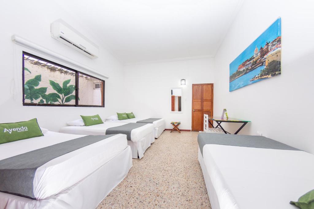 Postel nebo postele na pokoji v ubytování Hotel Ayenda Casa Cano 1805