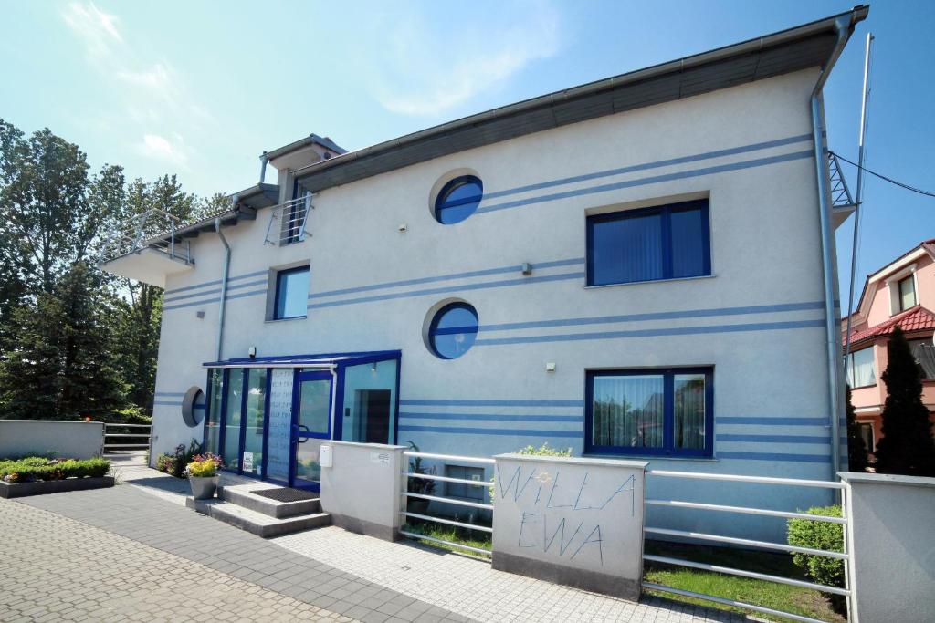 un edificio blanco con rayas azules en Willa Ewa, en Łeba