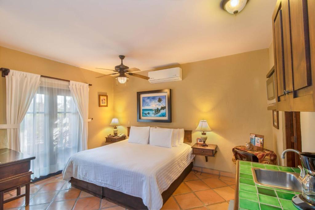 - une chambre avec un lit et un ventilateur de plafond dans l'établissement Posada del Cortes, à Loreto