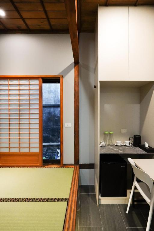 una cucina con bancone, tavolo e finestra di Nenggao Club B&B a Puli