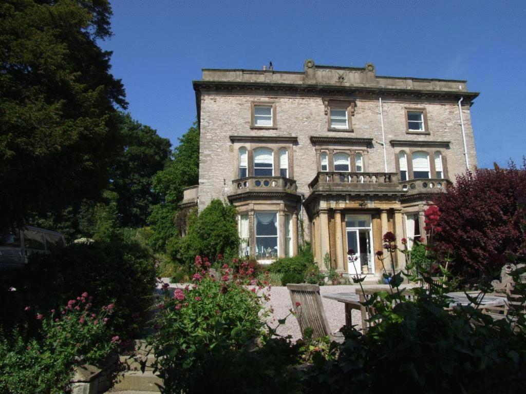 an old stone house with a garden in front of it at Castle House B and B in Denbigh