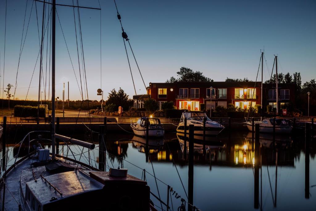 a group of boats docked in a marina at dusk at PORT PUDDEMIN Wohnungen an der Marina in Puddemin