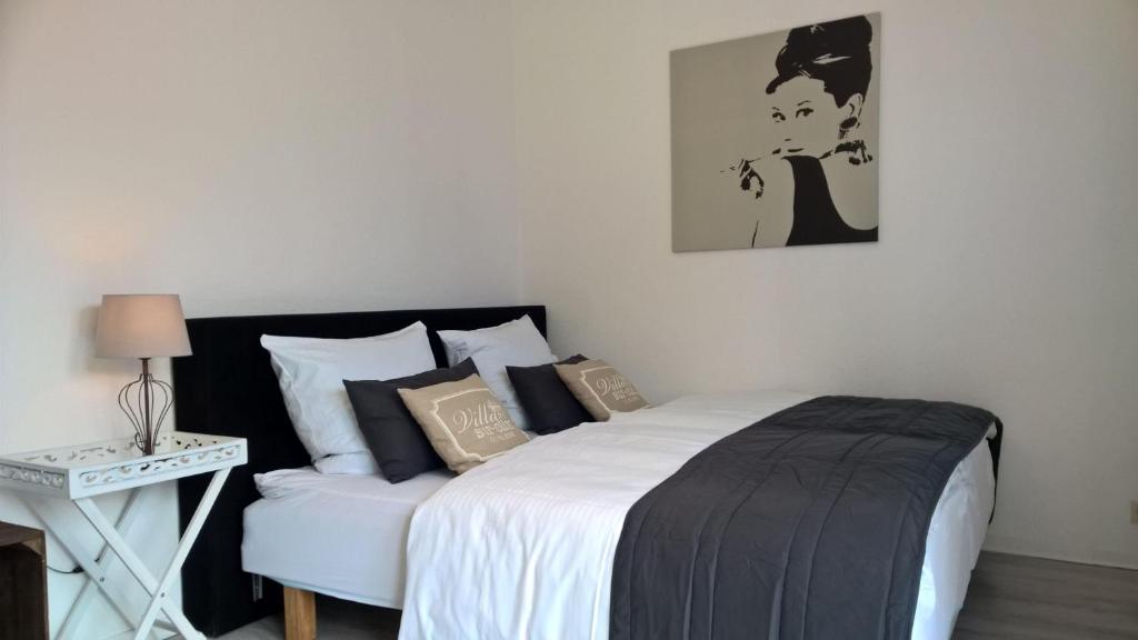 Schlafzimmer mit einem Bett mit einer schwarzen und weißen Bettdecke in der Unterkunft Urlaubsdomizil Burg Erdgeschoss in Fehmarn