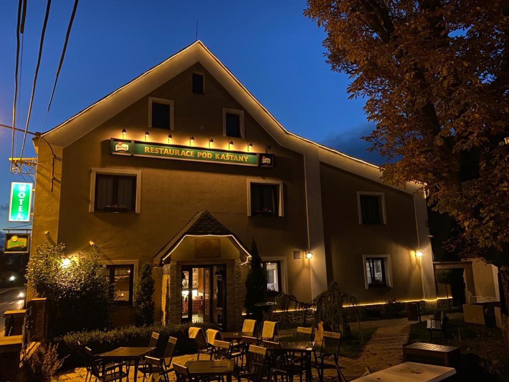 a restaurant with tables and chairs in front of a building at Hotel & Restaurant Pod Kaštany in Krupka - Marsov