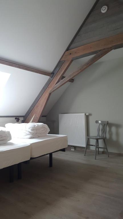 um quarto com uma cama num sótão em b&b onZENhof em Heuvelland