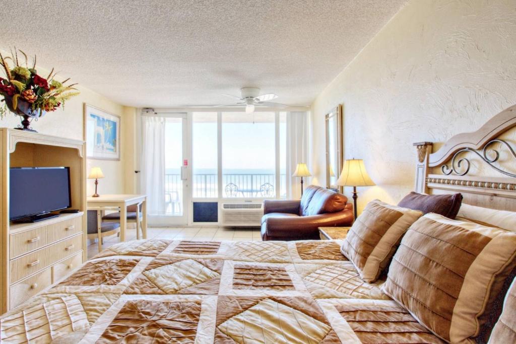 a bedroom with a large bed and a living room at Pirates Cove Condo Unit #614 in Daytona Beach