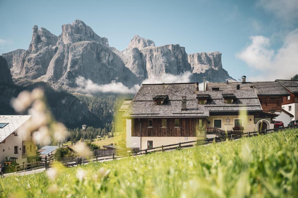 a village with a mountain in the background at Ciasa Altonn in Colfosco