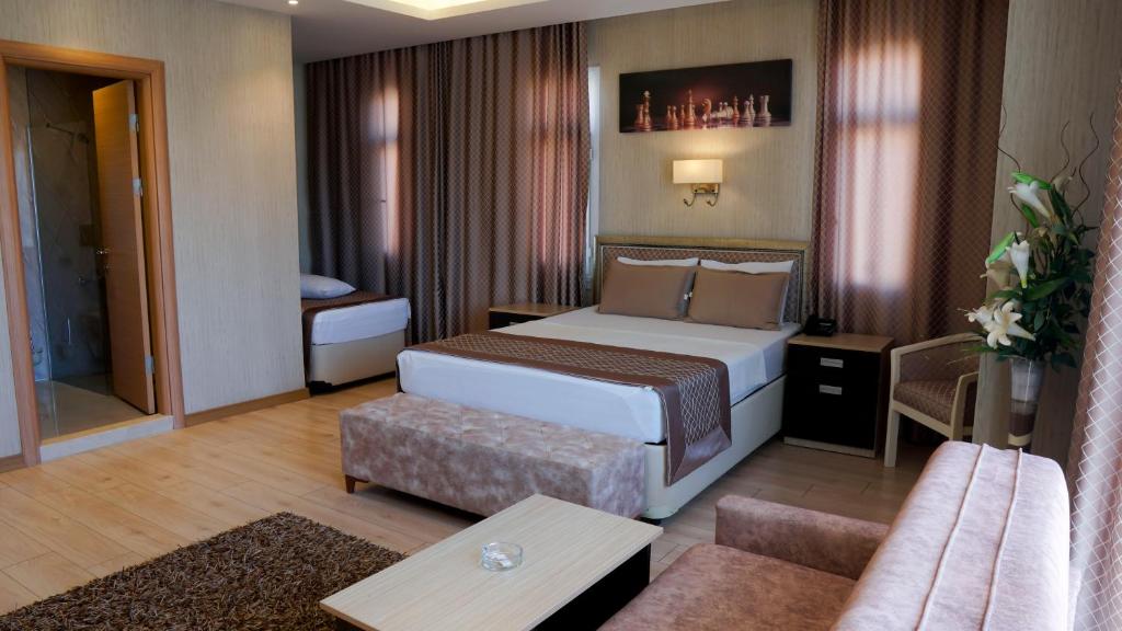 um quarto de hotel com uma cama e um sofá em Othello Hotel em Mersin