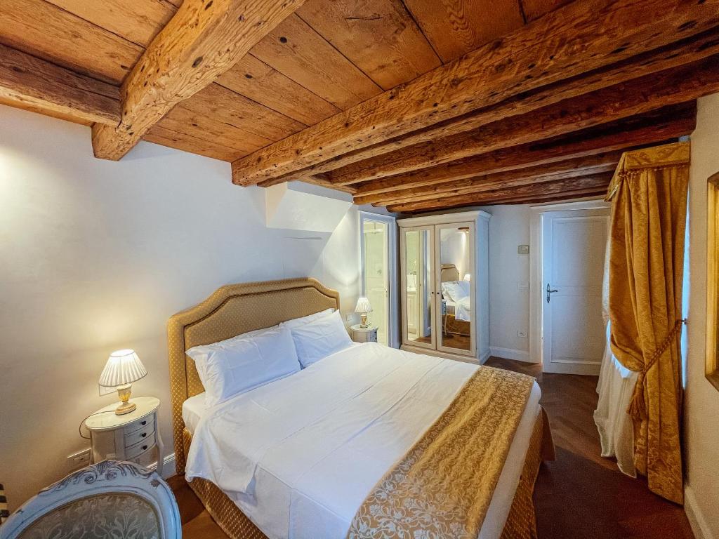 een slaapkamer met een wit bed en een houten plafond bij Ai Savi di Venezia in Venetië