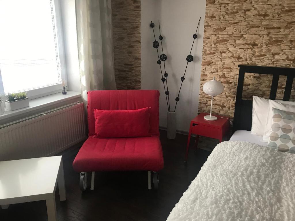 ロジュノフ・ポト・ラドホシュチェムにあるApartments Centrumのベッドルーム(赤い椅子、ベッド付)