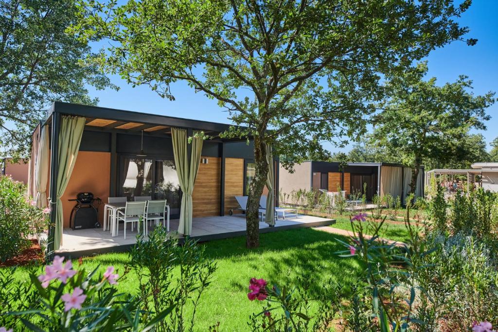 a modern house with a garden in the foreground at Camping Park Umag Mobile Homes in Umag