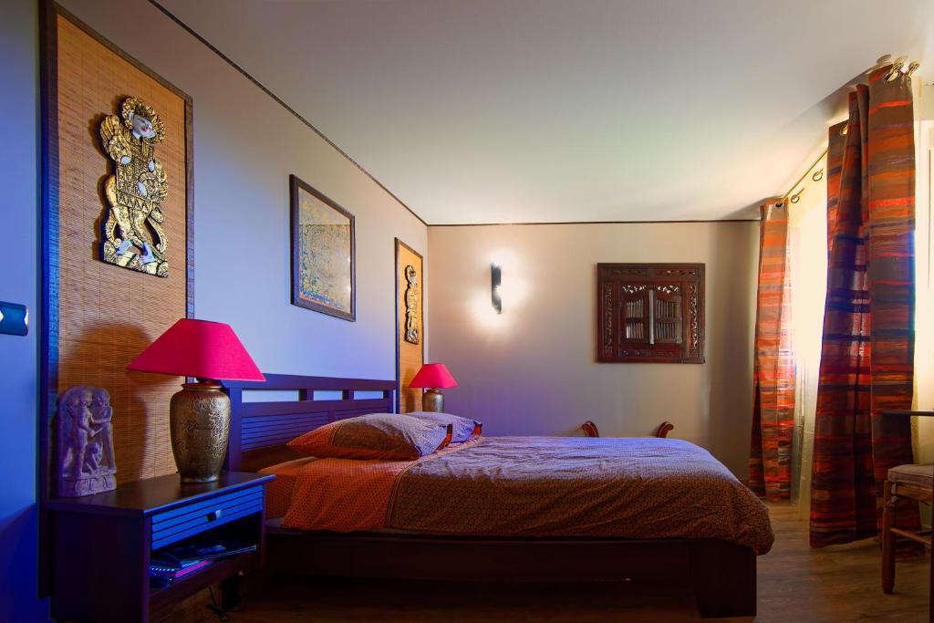 - une chambre avec un lit et une table avec deux lampes dans l'établissement Champagne Gilmaire-Etienne, à Binson-et-Orquigny