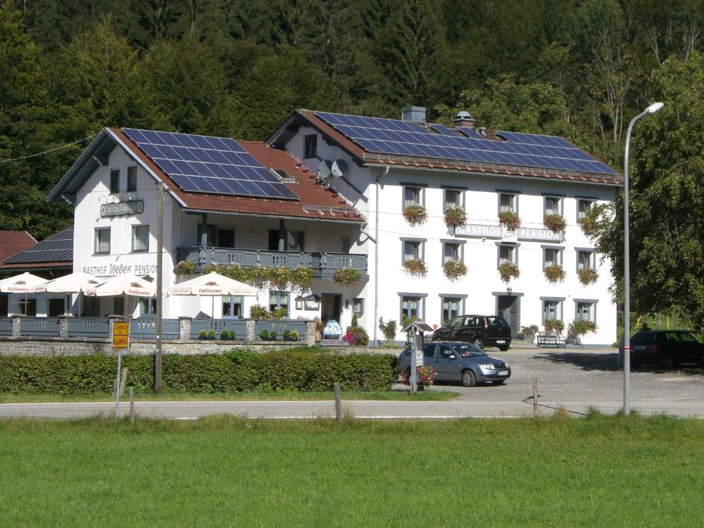 ein großes weißes Gebäude mit Sonnenkollektoren auf dem Dach in der Unterkunft Zur Alten Dampfsäge - Gasthaus-Pension Weber in Lindberg