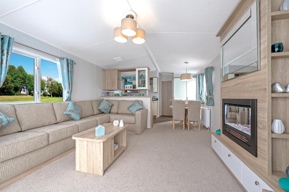 a living room with a couch and a tv at Par Sands Coastal Holiday park in Par