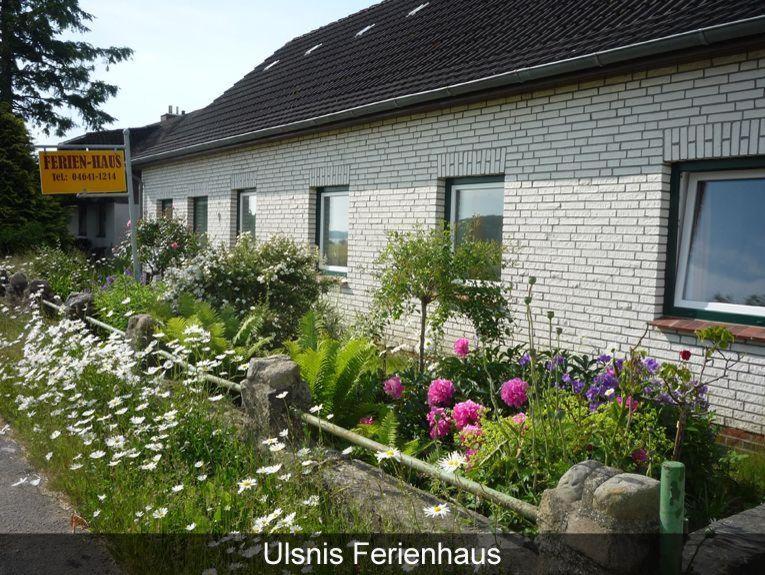 a garden with flowers in front of a building at Ferienhaus-Krohn-Schleiblick in Ulsnis
