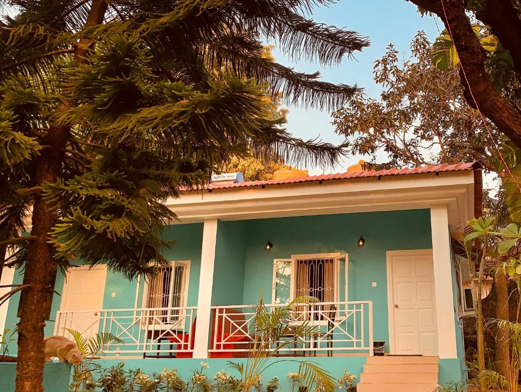 a green house with a balcony on top of it at Stan-Inn, North Goa, Vagator, with strong WIFI,free private parking & kitchen, Can Cook where you stay in Vagator