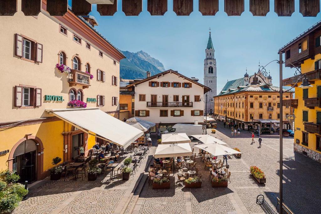 una vista aérea de una calle de la ciudad con mesas y sombrillas en Royal Hotel Cortina en Cortina dʼAmpezzo