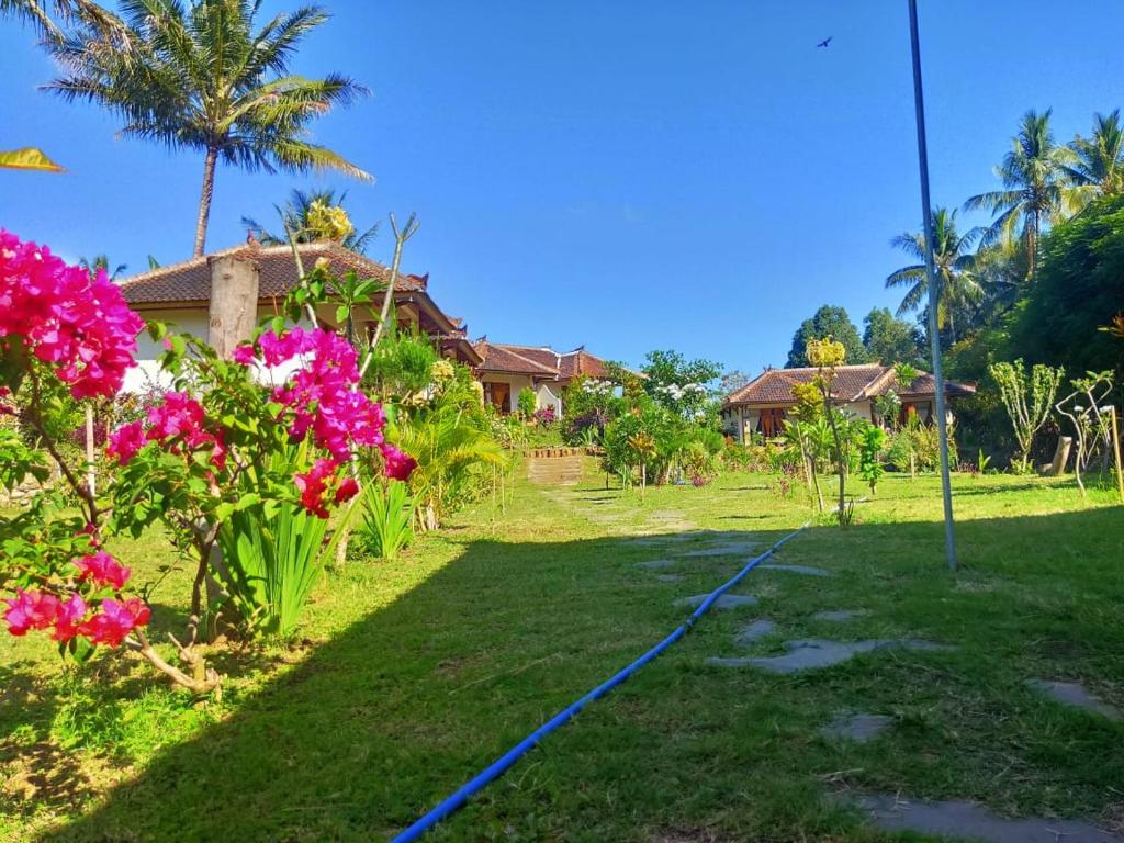 a yard with a hose in front of a house at Bale Sebaya Bungalows in Senaru