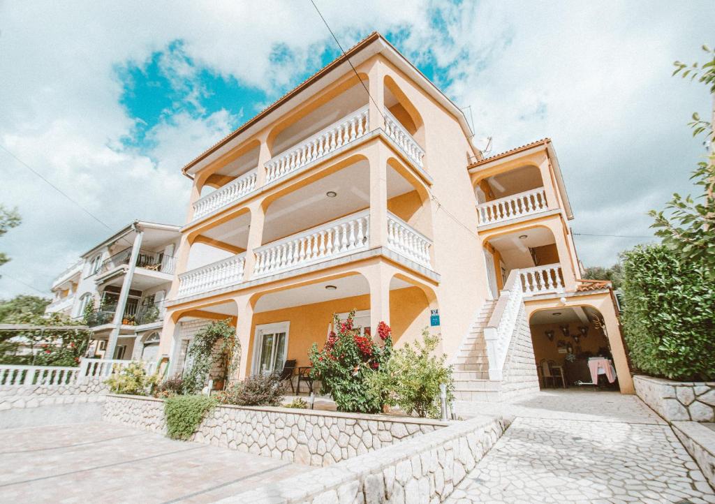 a large white house with white balconies at Apartments Vukic in Crikvenica