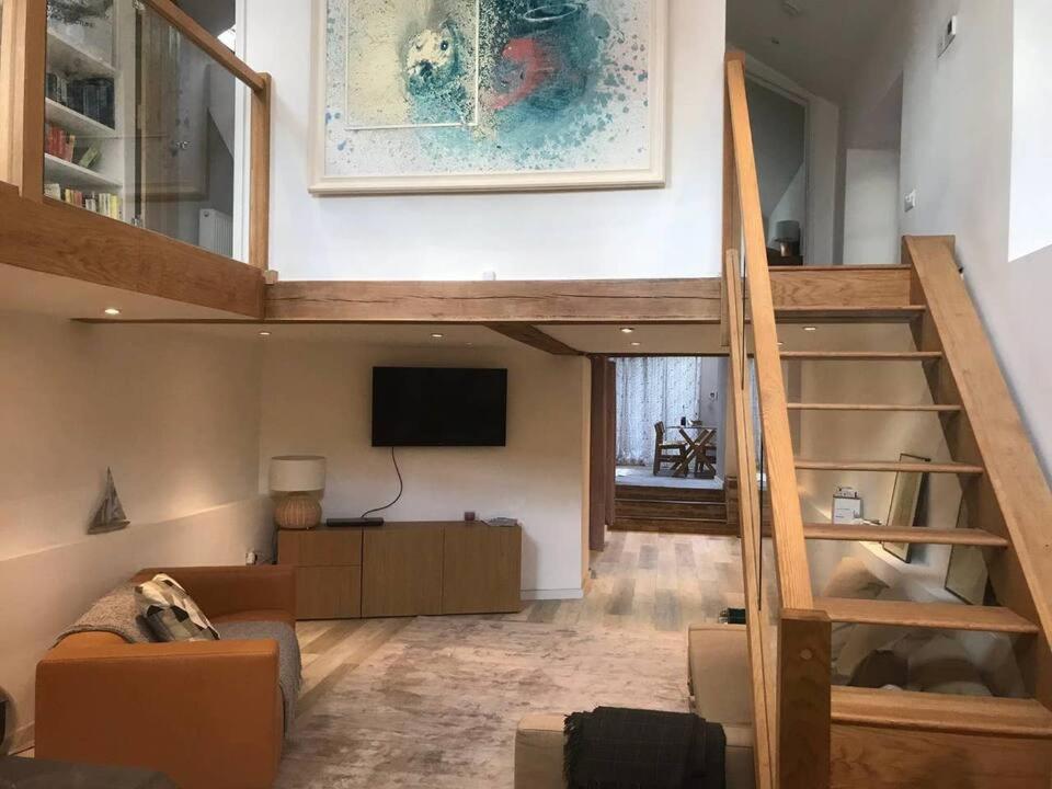 uma sala de estar com uma escada e uma televisão em Beautifully Converted Chapel em Blisland