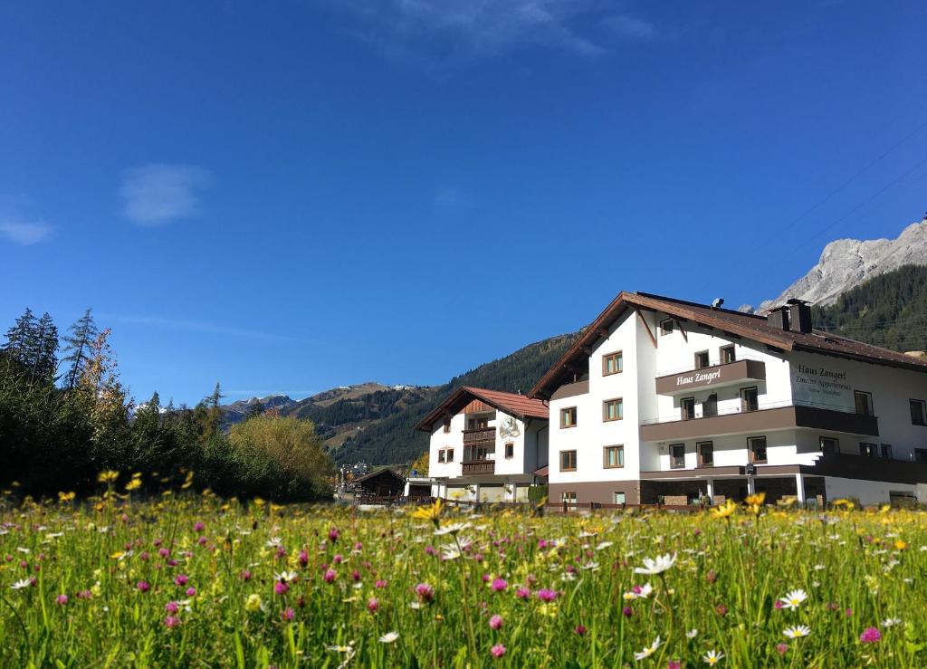 a building with a field of flowers in front of it at Haus Zangerl in Sankt Anton am Arlberg