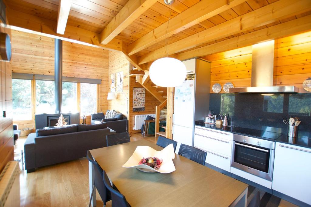 a kitchen and living room with a wooden ceiling at Cabana Coll Sisé in La Molina