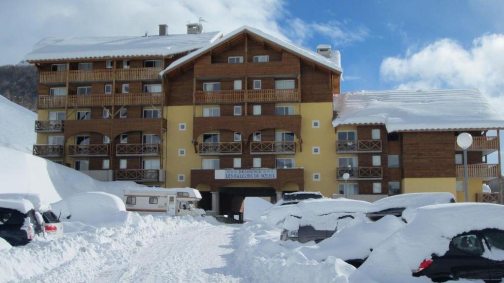 a snow covered parking lot in front of a building at La Foux d'Allos in La Foux