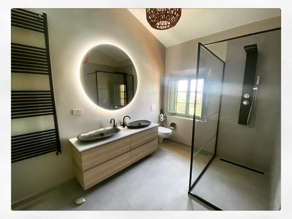 La salle de bains est pourvue d'un lavabo et d'un miroir. dans l'établissement Villa Casa Collina Castelfalfi with amazing salt waterpool & AIRCO & VIP service, à Castelfalfi