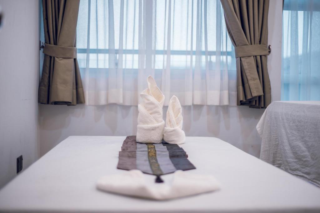 a pair of white socks and a towel on a bed at Casa Retreat in Hulhumale