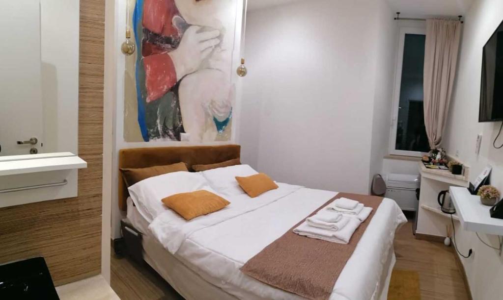 1 dormitorio con 1 cama blanca grande y lavamanos en Abbracci leandra Rooms, en Civitavecchia