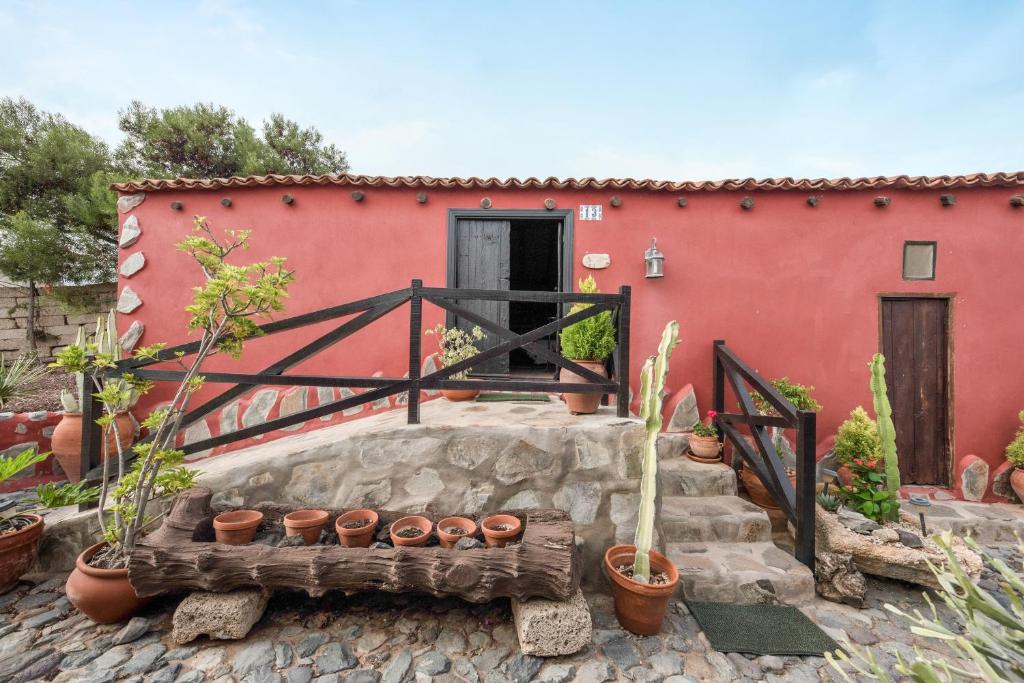 Casa Rural El Moral في Lomo de Arico: امامه بيت احمر به نباتات خزف