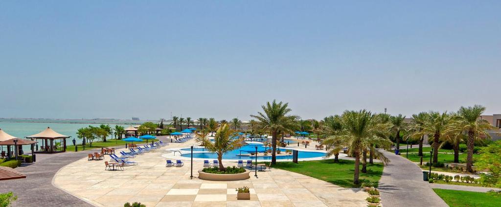 un complejo con piscina y palmeras en Simaisma A Murwab Resort en Sumaysimah