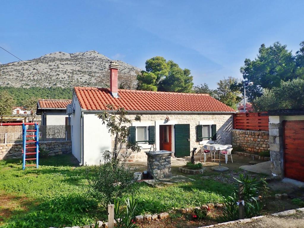 mały biały dom z czerwonym dachem w obiekcie Holiday home Cvita w mieście Starigrad-Paklenica