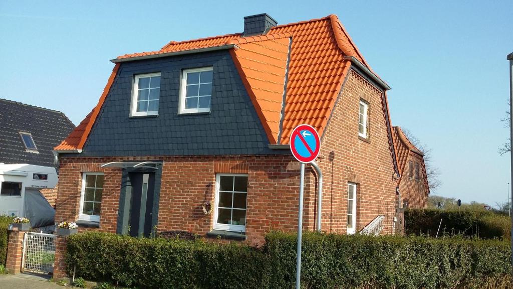 une maison en briques rouges avec un toit orange dans l'établissement Ferienhaus-Meereslust, à Petersdorf auf Fehmarn