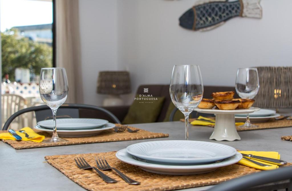 a table with plates and wine glasses on it at Blue Apartment Balaia Space - By Dalma Portuguesa in Albufeira