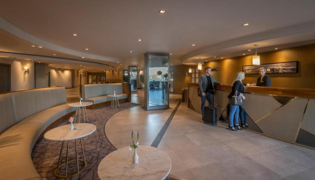 una hall con due persone in piedi al bancone di Maldron Hotel Tallaght a Tallaght