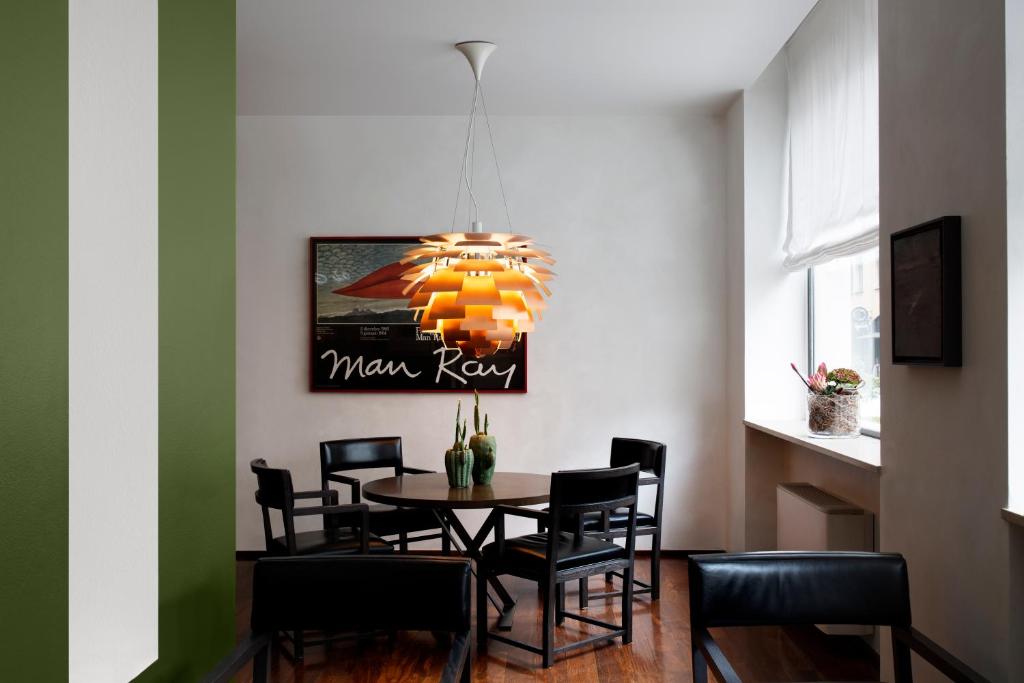 a dining room with a table with chairs and a chandelier at Hotel Colombia in Milan