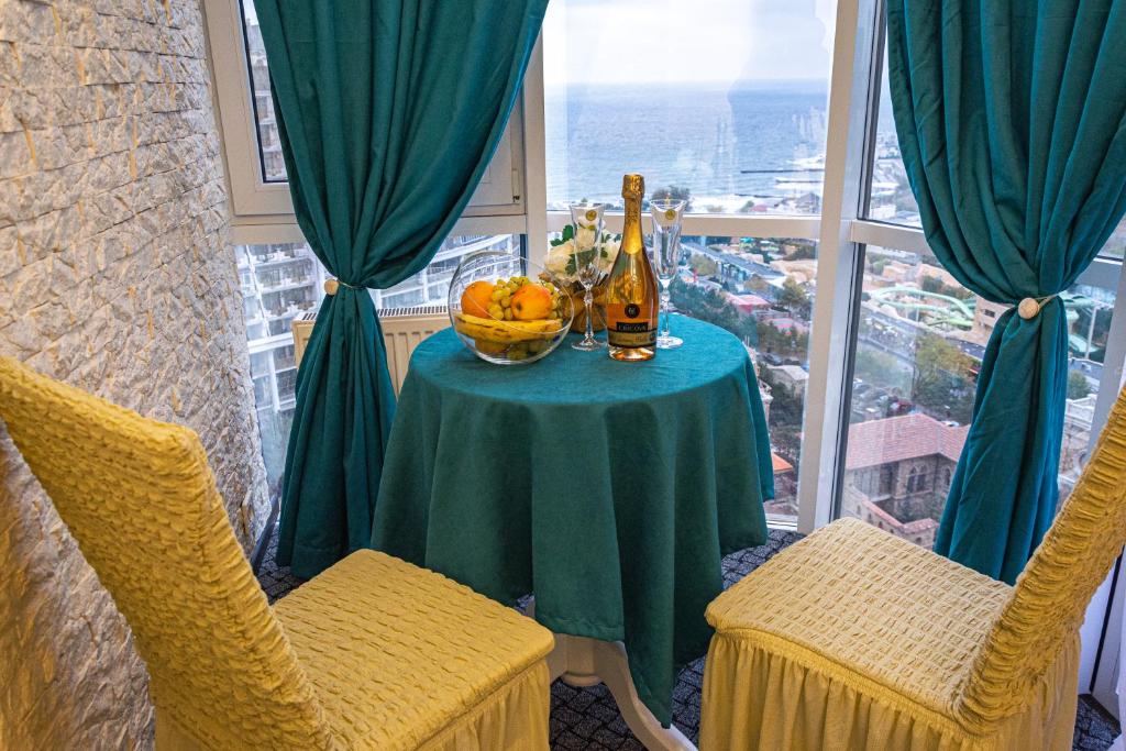 een tafel met een fles champagne en een fruitschaal bij Arkadia apartment with sea view in Odessa