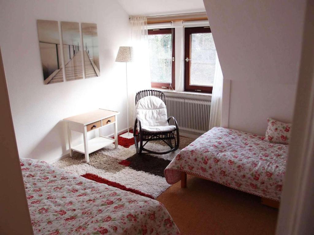 a bedroom with two beds and a desk and a chair at schoene-3-Zimmer-Ferienwohnung-in-St-Dionys-bei-Lueneburg in Sankt Dionys