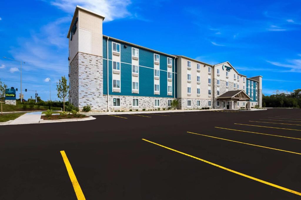 um parque de estacionamento vazio em frente a um edifício em WoodSpring Suites Chicago Addison em Addison