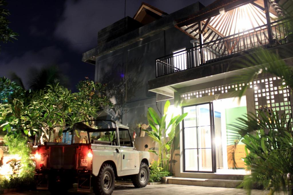 a white truck parked outside of a house at night at EUFORIA Guest House in Canggu