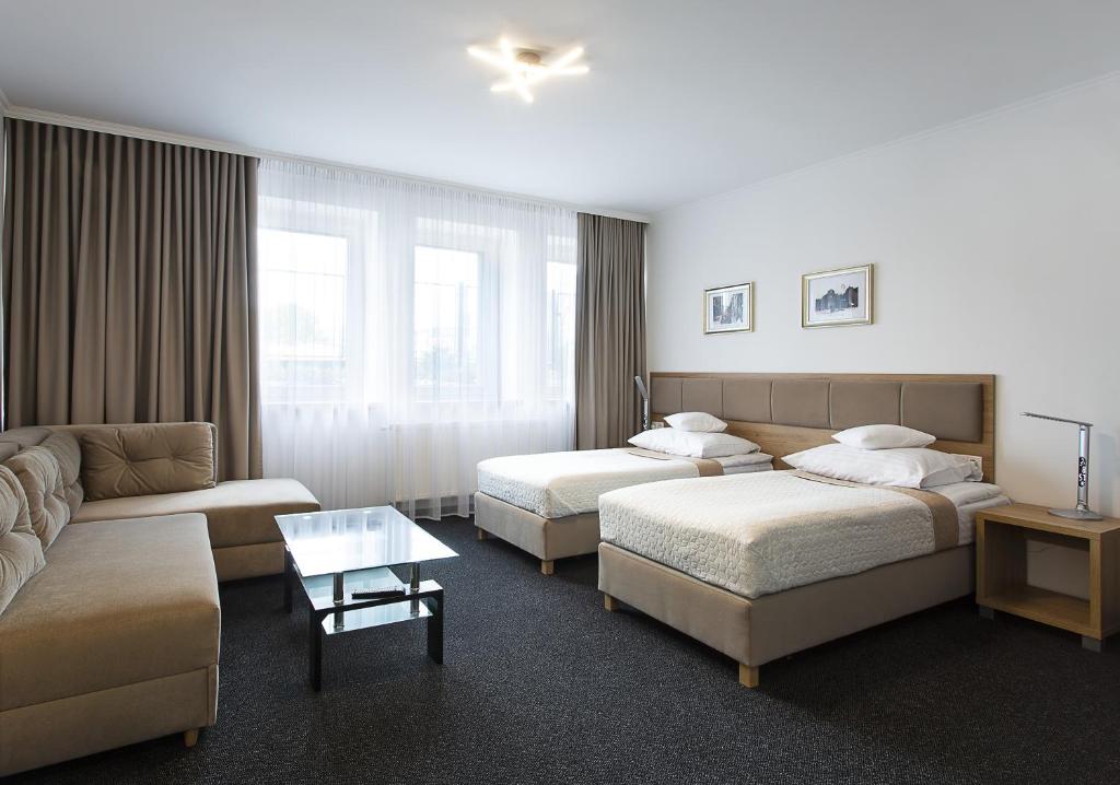 a hotel room with two beds and a couch at InterHotel in Wrocław